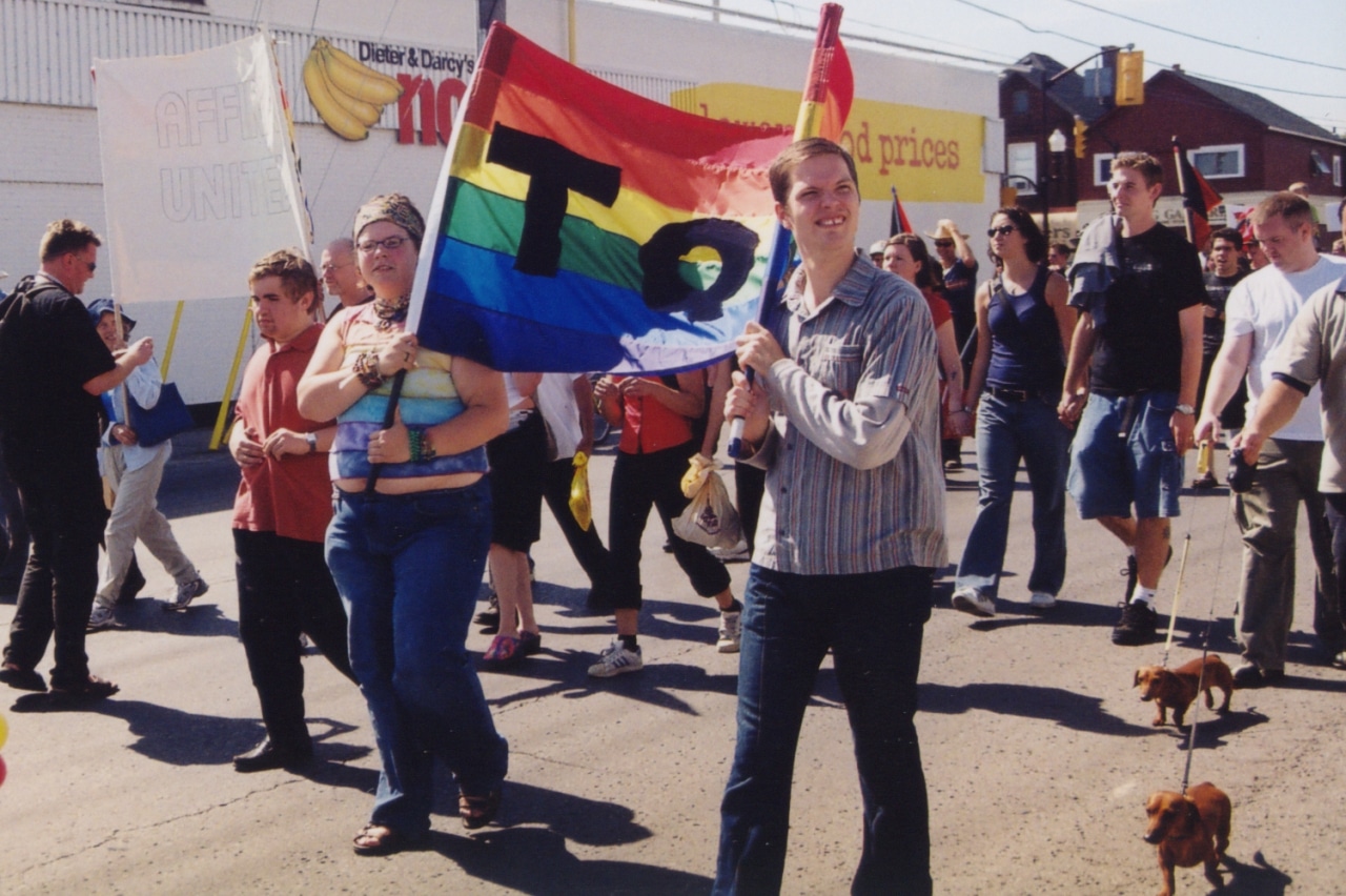 Marchers in Peterborough's first Pride parade in 2003 hold a rainbow banner on Sherbrooke Street.