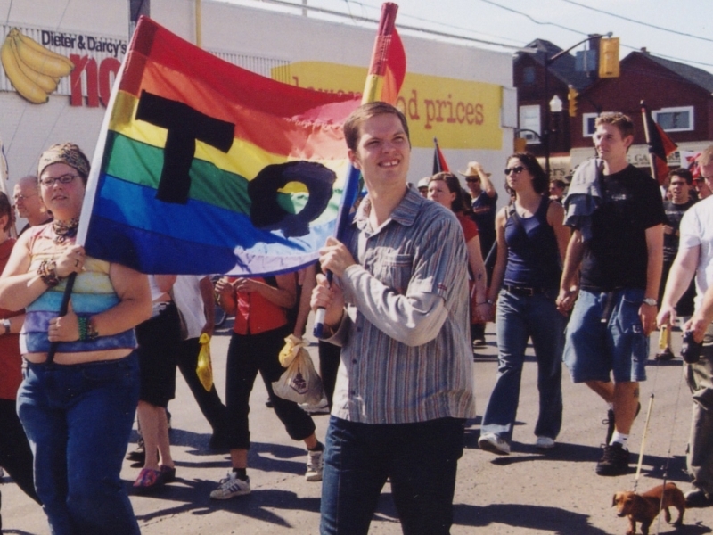 Marchers in Peterborough's first Pride parade in 2003 hold a rainbow banner on Sherbrooke Street.