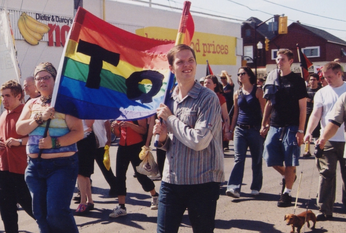 Marchers in Peterborough's first Pride parade in 2003 hold a rainbow banner on Sherbrooke Street.