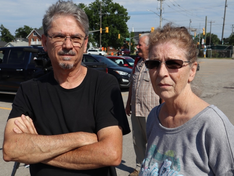 Ray and Wendy Nadon stand in a parking lot on a sunny day.