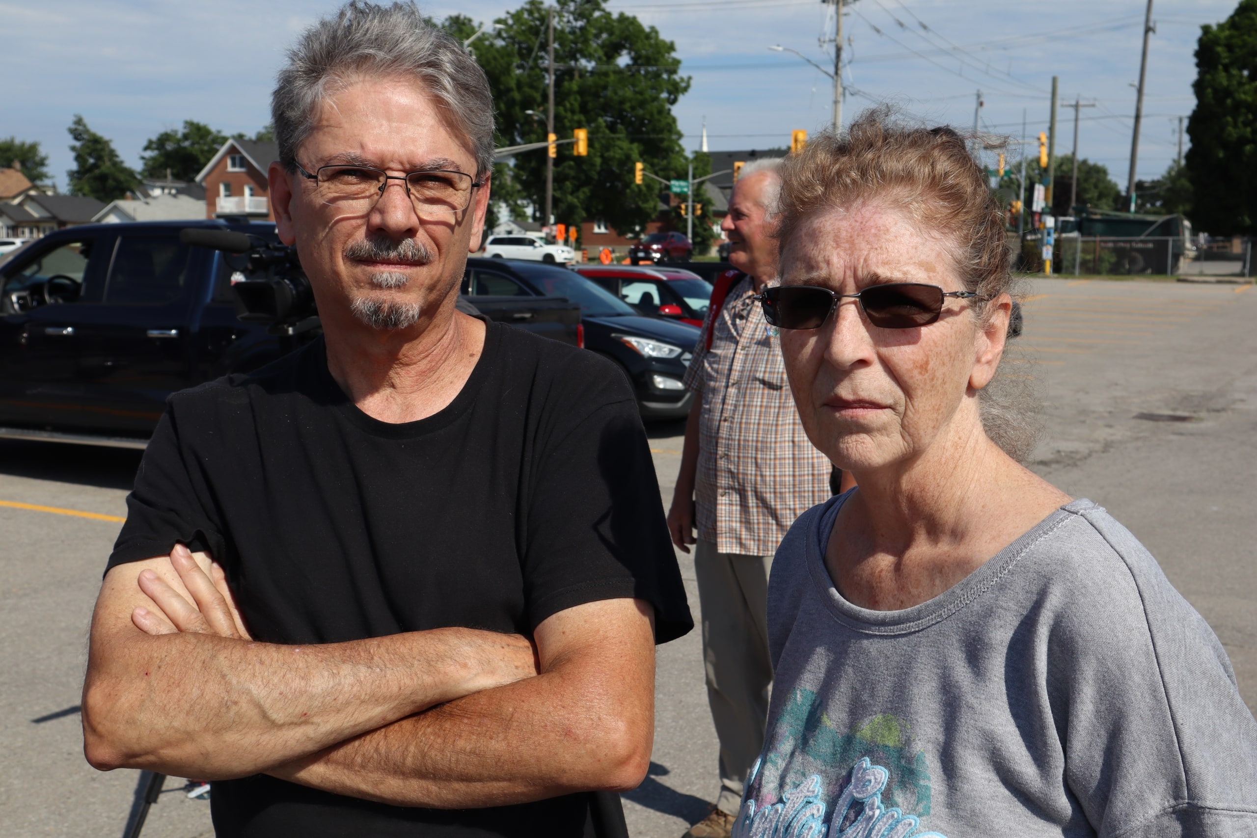 Ray and Wendy Nadon stand in a parking lot on a sunny day.