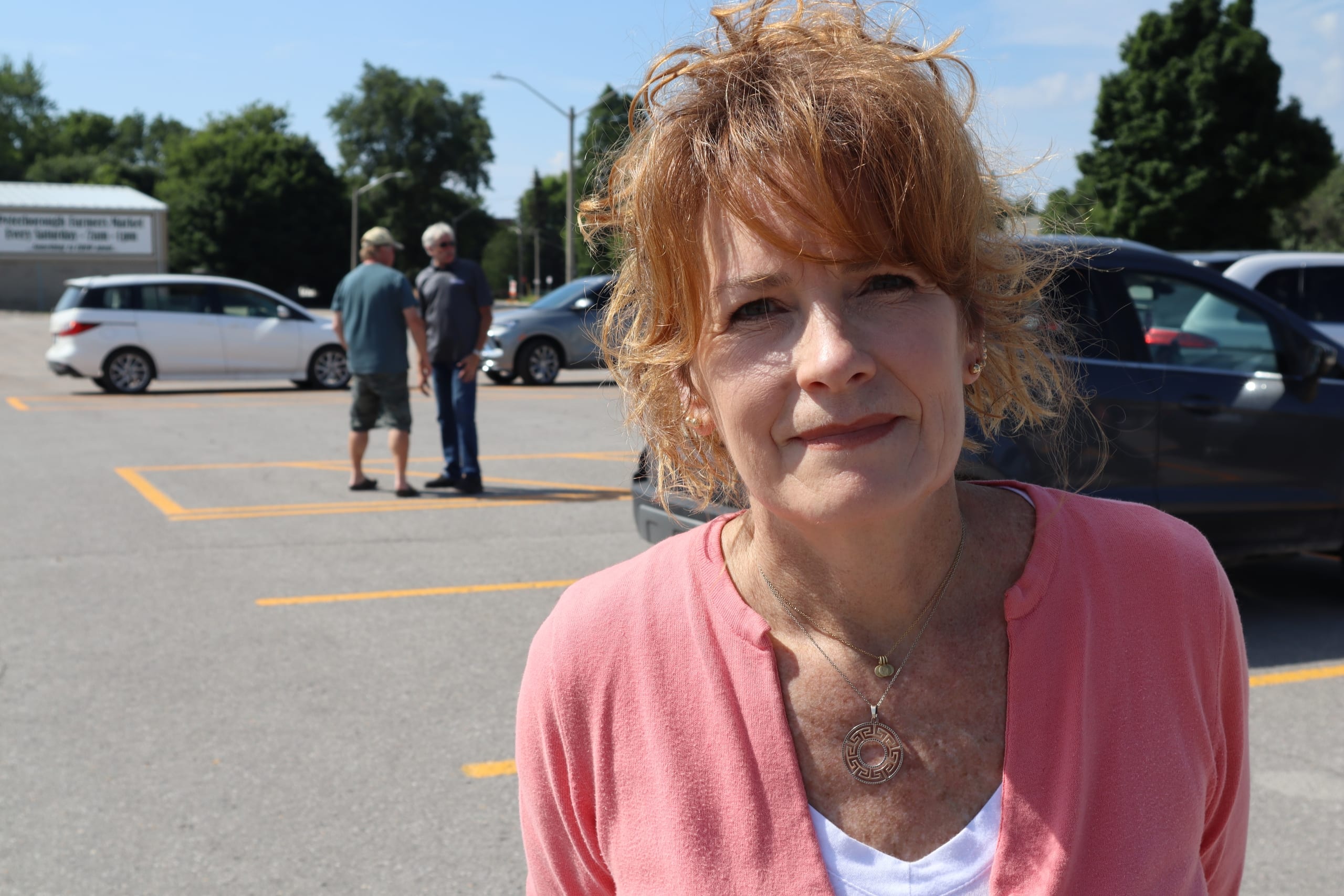 Photo shows bus driver Wendy Hargreaves standing in a parking lot on a sunny day.